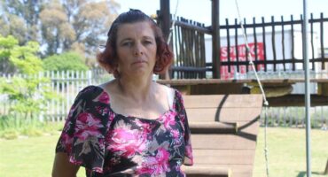 Woman with an abdominal mass stands in front of a jungle gym