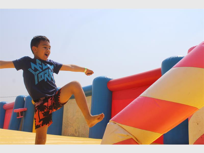 Boy jumps on a giant bouncy castle.