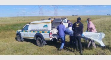 body is being loaded into a police morgue van