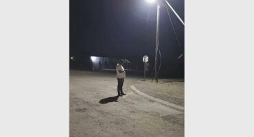 A person stands under a street light.