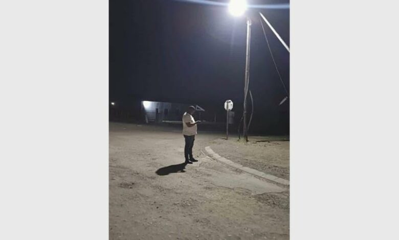 A person stands under a street light.