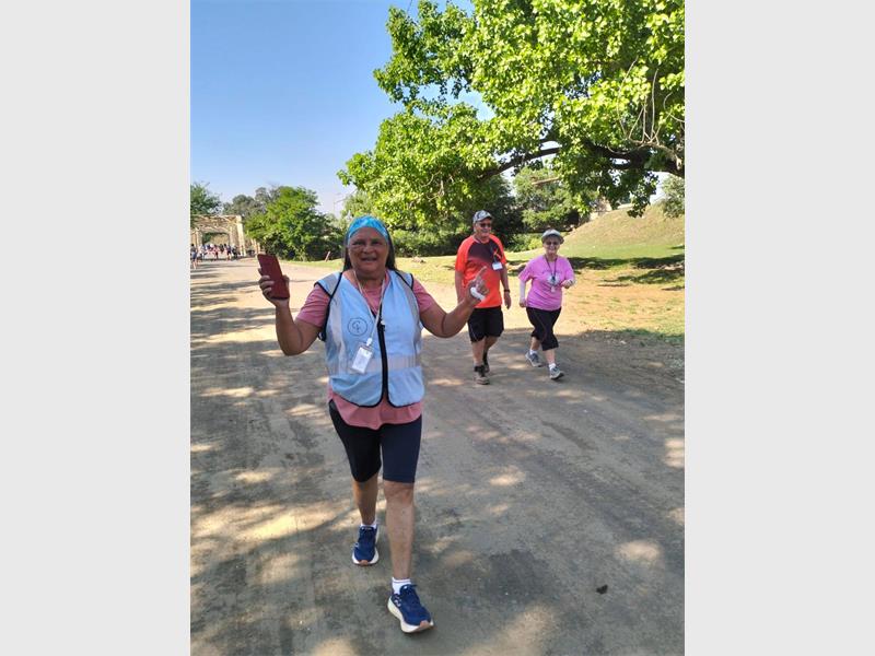 Walking woman waves for photographer