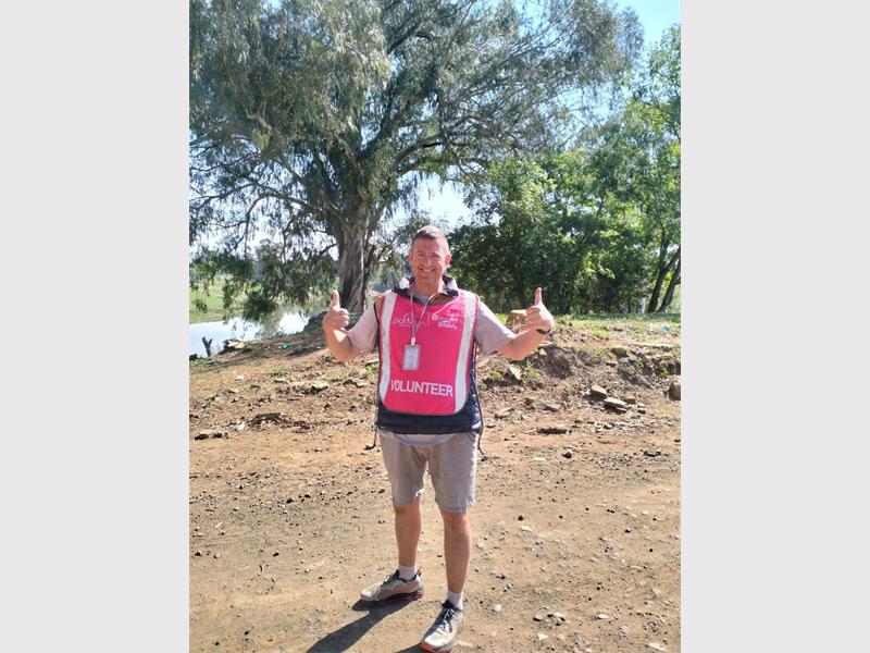 Man with pink bib shows thumbs up.