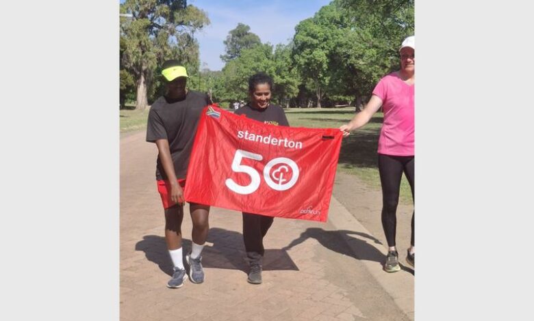 Woman with a banner for 50 parkruns