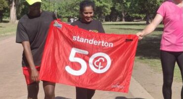 Woman with a banner for 50 parkruns