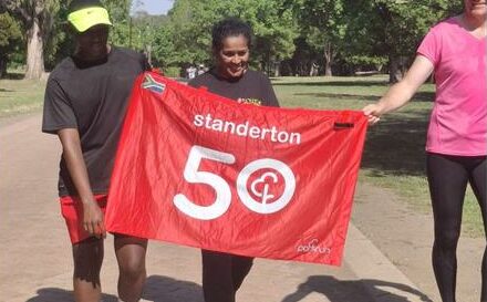 Woman with a banner for 50 parkruns