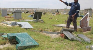 a man show many broken tombstones