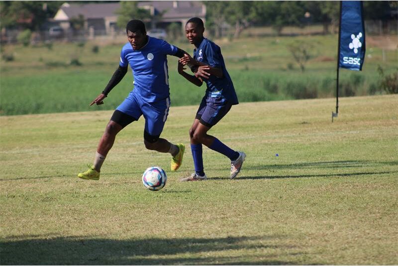 two soccer players vie for the ball