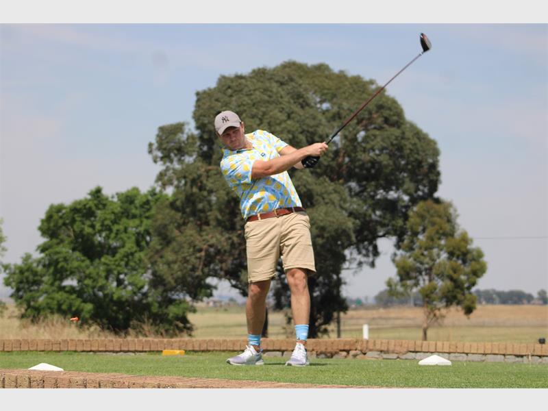 golf player tees off.