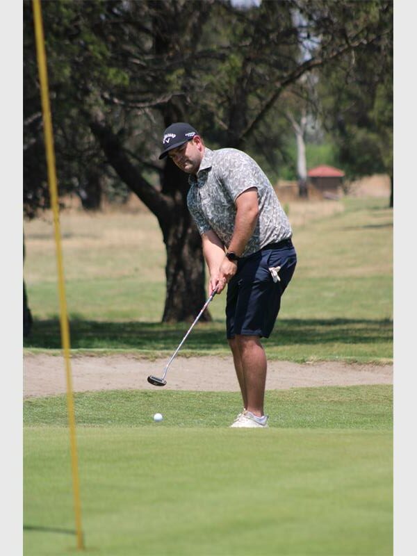 Man in grey shirt puts for the hole.