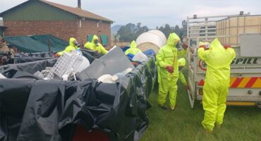 People in hazmat suits clean a crime scene