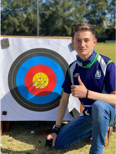 boy shows thumbs up at an archer's target