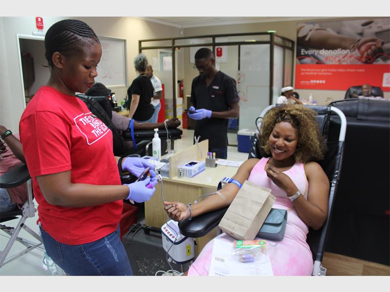 nurse helps to draw woman's blood