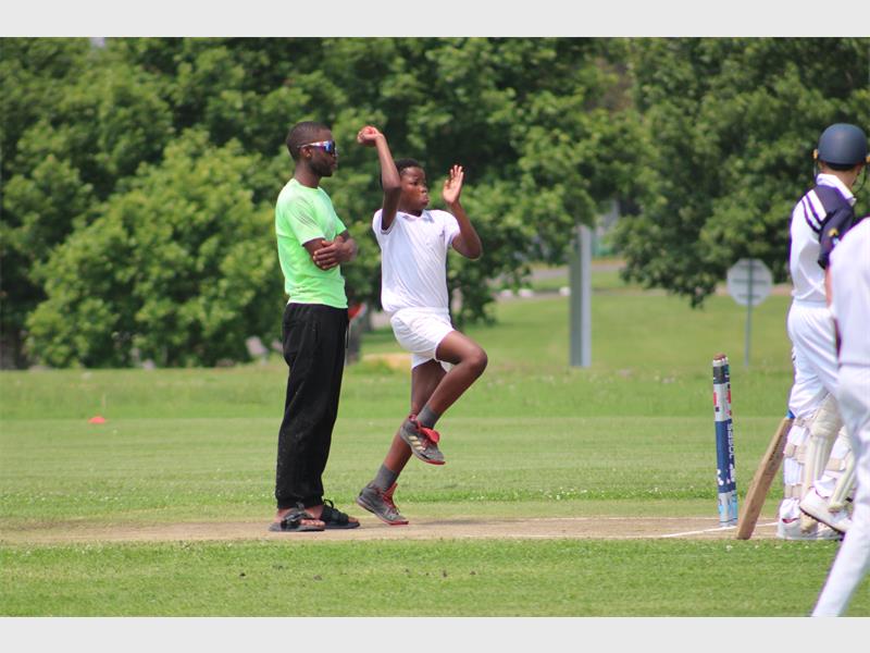 A young cricket player bowls
