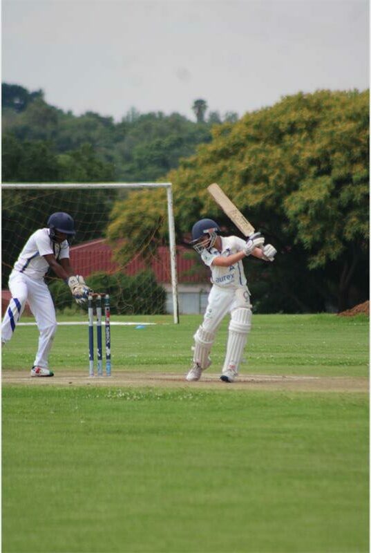 A young cricket player bats