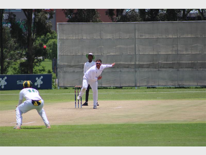 A senior cricket player bowls