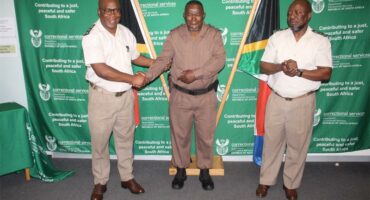 three people wearing prison warder uniforms