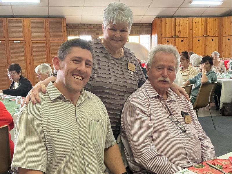 Elderly woman with her hands on the shoulders of two men