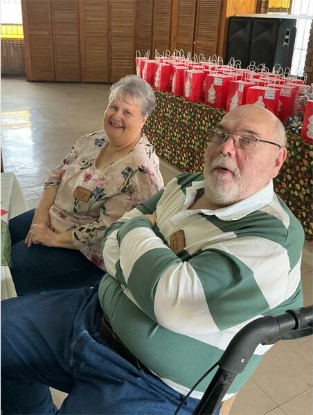 Two people sitting in a hall.