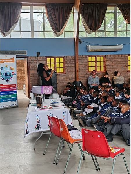 women speak to children in school hall