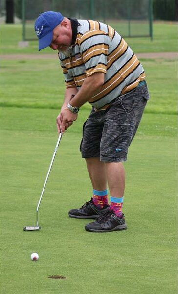 Golfer putts on the green.