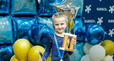 Little girl in leotard with a trophy