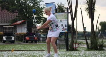 woman plays golf on course that is full of hail