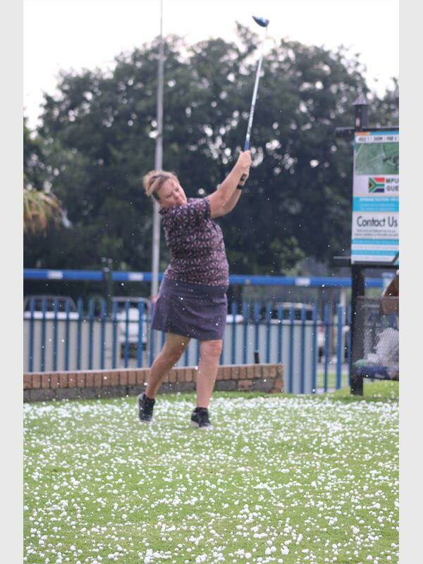 Woman golfer tees off