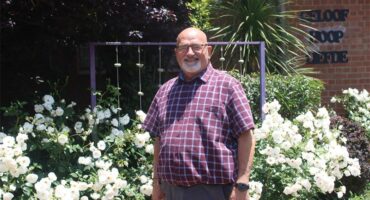 Principal stands in rose garden