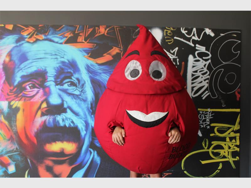 a blood drop mascot with einstein back drop