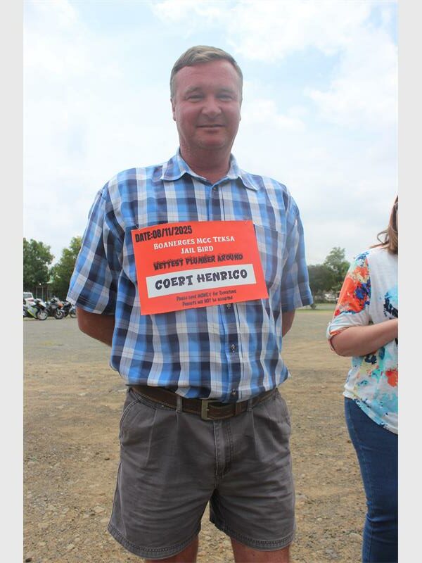 man with checkered shirt and sign around his neck