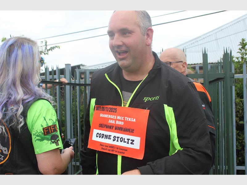 Man with orange sign around his neck smiles