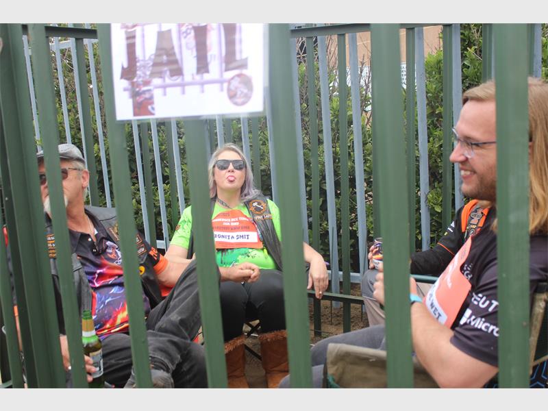 people sit inside a palisade cage