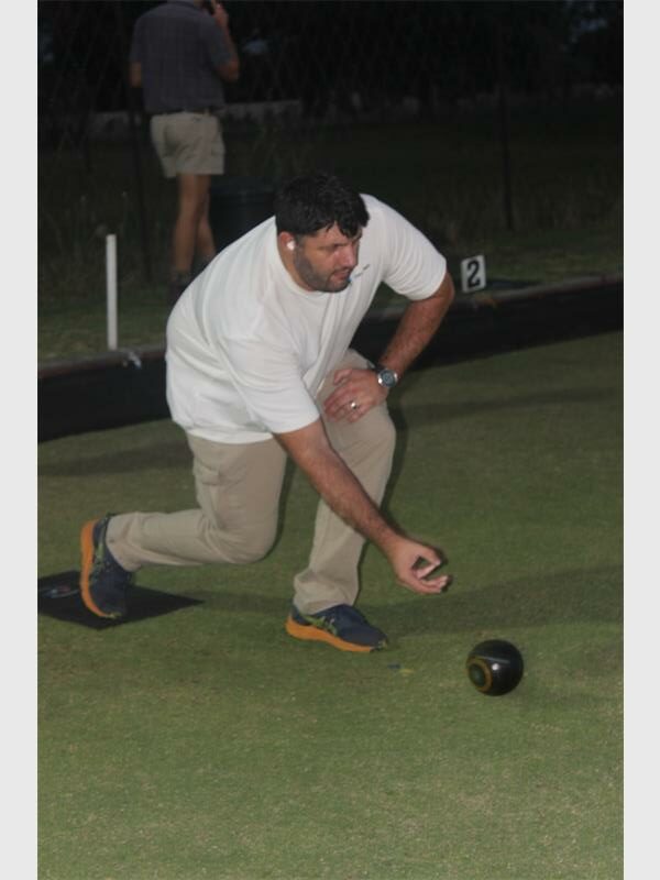 man in white shirt rolls the bowls