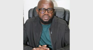 man with glasses and interlocking fingers