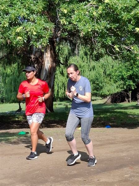 Two women run on dirt road