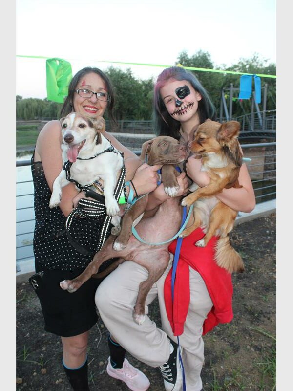 two women in halloween make up and three dogs