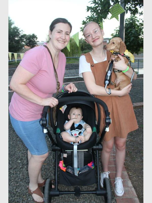 Two women with a baby in a pram and a dog