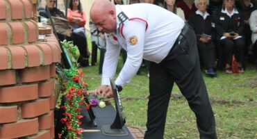 man in uniform lays down a wreath