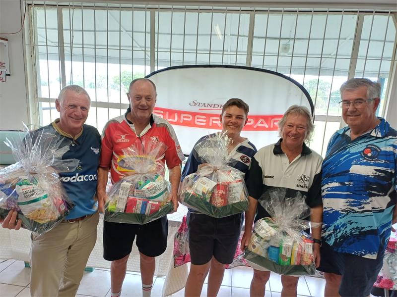 Five people in sport shirts with food hampers