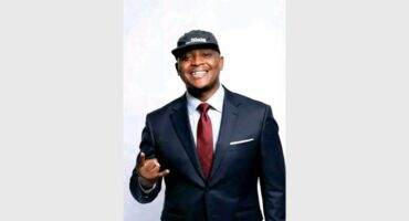 Man in suit with red tie and baseball cap