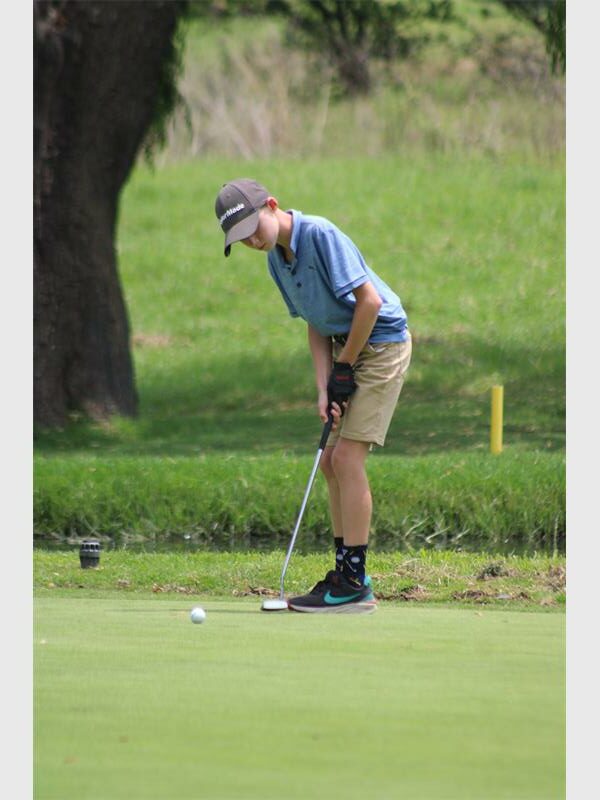 Boy putts on the greens