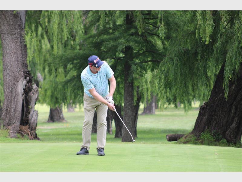 Golfer with light blue shirt on a golf course
