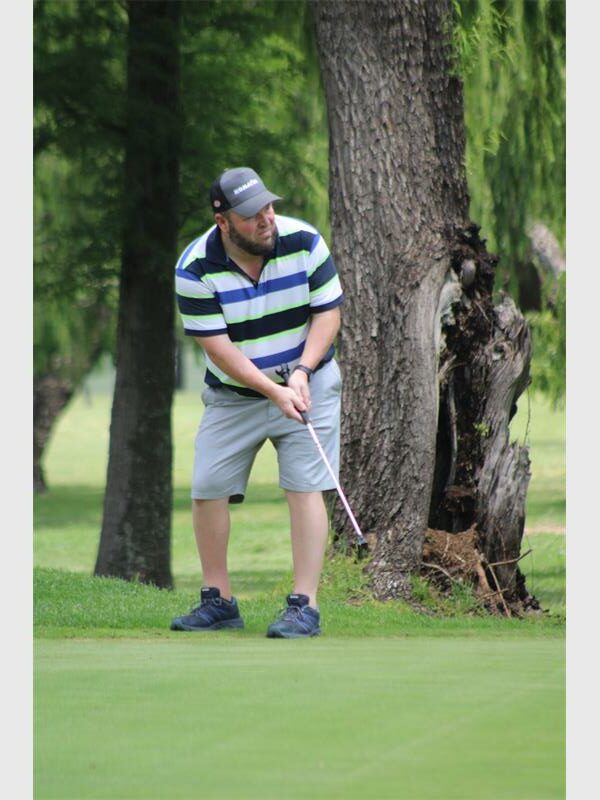 man in striped shirt plays through the fairway