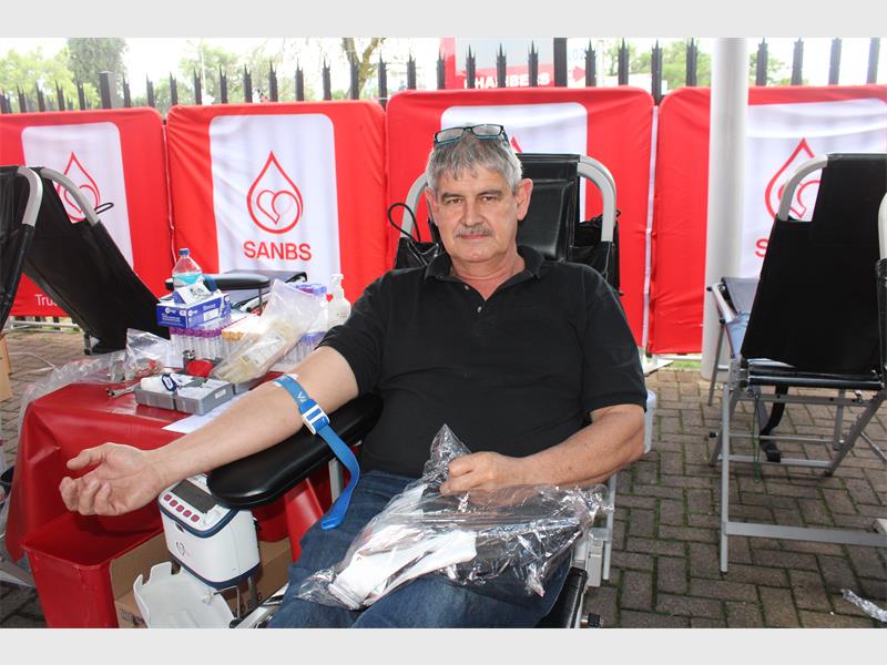 man with grey hair and moustache donates blood