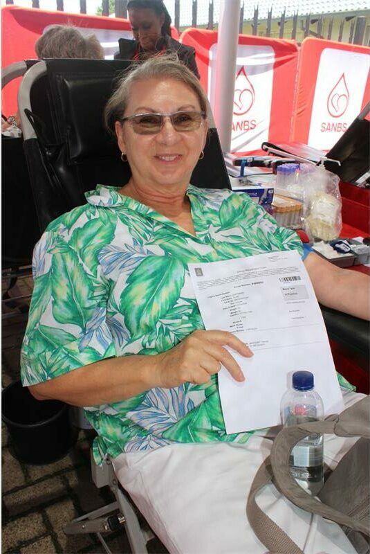 woman in patterned shirt holds up a form