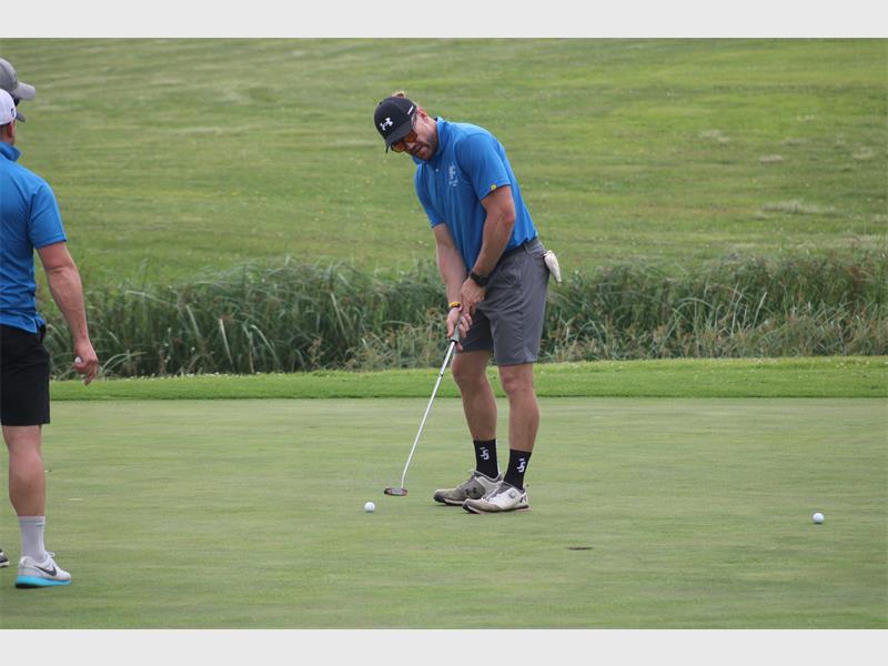 Gholfer with blue shirt on the greens