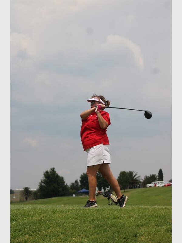 woman golfer tees off
