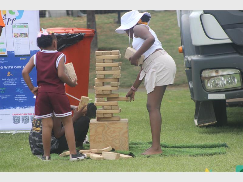 people play Jenga with big blocks