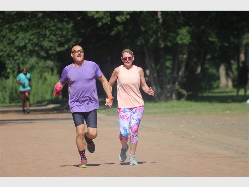 Theo and Karien Schonveldt cross the end line holding hands.